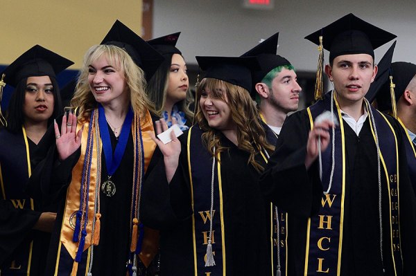 West Hills grads wave to their families as they enter the Golden Eagle Arena Thursday night at West Hills College Lemoore